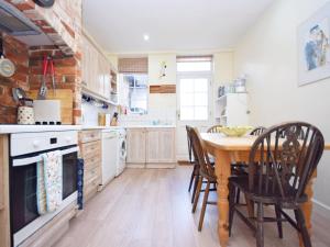 a kitchen with a wooden table and chairs at Pepper Pot Cottage in Compton