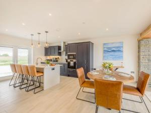 eine Küche und ein Esszimmer mit Tisch und Stühlen in der Unterkunft Apple Blossom Cottage in Ludchurch