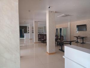 a lobby with tables and chairs in a building at Hotel Relax in Jāmb