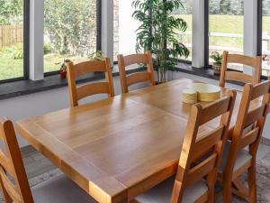 einen Holztisch und Stühle im Esszimmer in der Unterkunft Preselli View Cottage - Uk37755 in Ludchurch