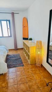 Habitación con mesa y tablas de surf en la pared en Casa Marinera El Cotillo duplex for 2-4 persons, en Cotillo