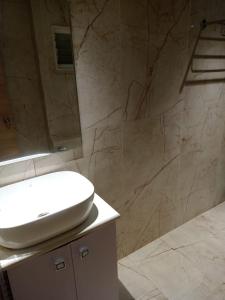 a bathroom with a white sink and a shower at Hotel Relax in Jāmb +21 photos