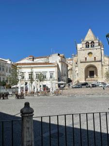 an old building with a fence in front of a street at Janelas do Governador in Elvas