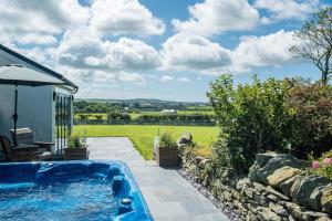 a swimming pool in a garden with a view of a field at Bryndeusant in Llanbabo