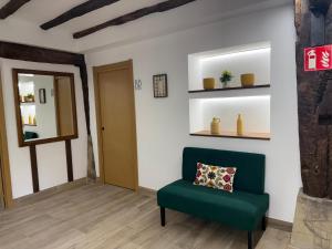 a living room with a green chair and a mirror at Arandi Baserria in Urigoiti