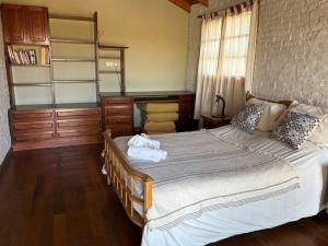 a bedroom with a large bed and a book shelf at El retoño in San Antonio de Areco +9 photos