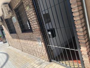a metal gate on the side of a brick building at Departamento habitación doble equipado full in Cordoba