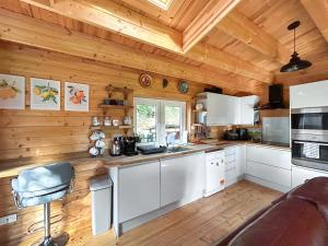 a kitchen with white cabinets and a wooden ceiling at The Cabin in Borough Green
