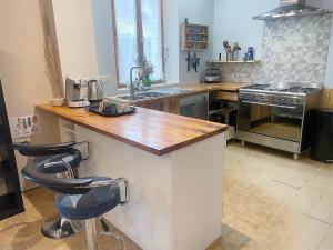 a kitchen with a counter top and a stove at La Family House, spacieuse avec wifi, extérieur et parking in Cormicy