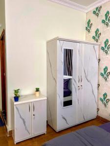 a white cabinet with a mirror in a room at Hotel Maski Suties in Kondapur