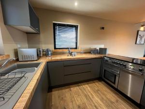 a kitchen with a sink and a stove at White Cairn - Uk50484 in Kylestrome