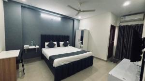 a bedroom with a bed and a desk in a room at Hotel Maski Suties in Kondapur +9 photos
