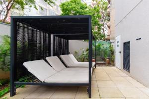 a black and white couch in a pergola on a patio at CGB302 - Apto com piscina e academia Bela Vista in Sao Paulo