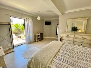 Cape TownにあるLa rambla guest houseのベッドと鏡付きのドレッサーのある寝室