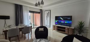 a living room with a dining table and a television at Domaine de noria in Marrakesh