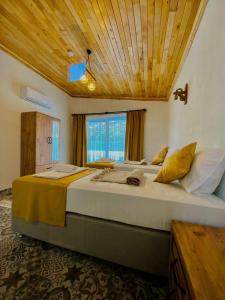 a bedroom with a large bed with a wooden ceiling at Kent Villas in Demre