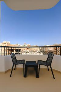 a table and two chairs on a balcony at Diva Suites in Hurghada