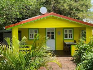 una casa amarilla con una mesa delante en Ti Kaz, en Sainte-Anne