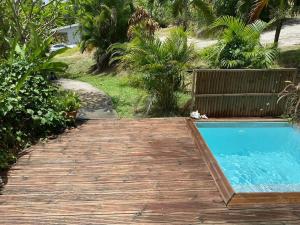 una pasarela de madera que conduce a la piscina en Ti Kaz, en Sainte-Anne 1 foto más
