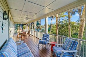 a porch with chairs and tables and palm trees at SM09: 9 Silver Moss in Kiawah Island