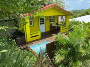 una casa amarilla con una piscina frente a ella en Ti Kaz, en Sainte-Anne