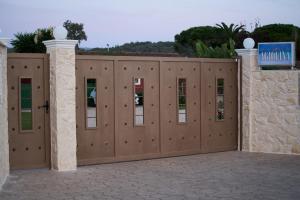 Un conjunto de puertas de madera en un camino de entrada. en Villa Agiolina, en Sidari