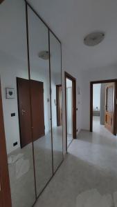 a large mirror in a room with several doors at A casa di Gina in Airasca