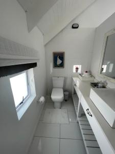 a white bathroom with a toilet and a sink at Bougain Villa in Paternoster +33 photos