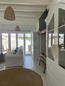 a living room with a white couch and a television at Bougain Villa in Paternoster