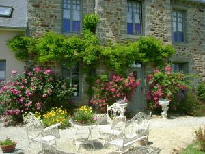 a group of chairs and flowers in front of a building at La Porte Ouverte in Saint-Denoual