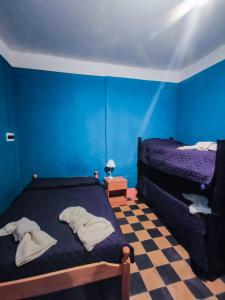 una camera da letto blu con un letto e un pavimento a scacchi di Departamentos los Abuelos a Fiambalá