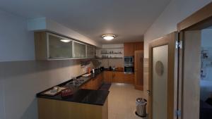 a kitchen with wooden cabinets and a black counter top at Luxury apartment in Espinho