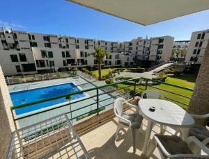 a balcony with a table and chairs and a swimming pool at Apartamento 2 Dormitorios Las Americas in Playa de las Americas