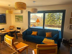 a living room with a blue couch and a table at Siedlisko Pod Szczerbakiem in Szczawnica