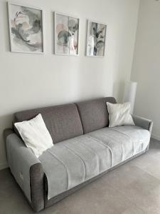 a couch in a living room with four pictures on the wall at Casa Vacanze da Marco & Carmela in Perugia +21 photos