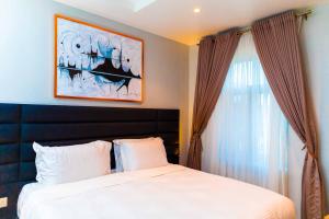 a bedroom with a white bed and a window at King Georges Court in Mama