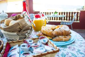 a table topped with a basket of pastries and orange juice at B&B Va' Pensiero in Villasimius