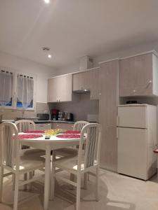 a kitchen with a table and chairs and a refrigerator at Appartement Amaryllis in Le Boulou