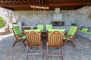 una mesa de madera y sillas con chimenea en el patio en Villa Magnolia, en Palaia Epidavros