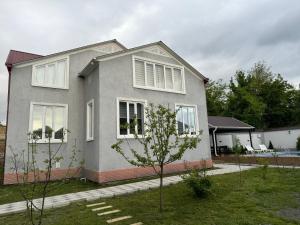 a gray house with white windows on a yard at Peak Paradise Gabala Villa in Gabala