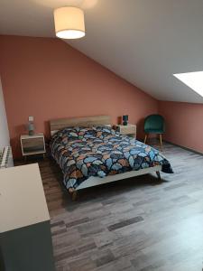 a bedroom with a bed and a green chair at Maison de campagne in Souvans