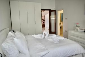 two swans sitting on top of a white bed at Villa Lu Bartolo - Room Lily in Taʼ Lampuka +15 photos