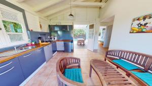 a kitchen with blue cabinets and two chairs in it at Colibri in Sainte-Anne