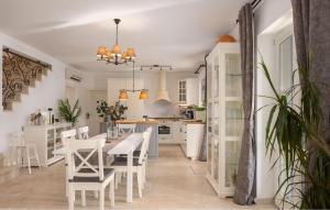 Una cocina con gabinetes blancos y una mesa y sillas. en Villa Mia, en Sveti Ivan Dobrinjski