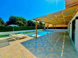 a patio with an umbrella and a swimming pool at Kent Villas in Demre