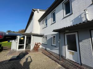a white house with a patio with a large door at EcoLodge 2