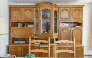 a wooden cabinet in a room with two chairs at Ferienwohnung Neuhermsdorf in Neuhermsdorf