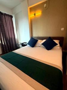 a bedroom with a large bed with blue pillows at Arrival View in Male City +1 photo