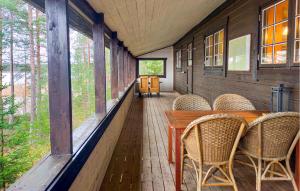 a porch with a table and chairs and windows at Nice Home In Kälarne With Sauna in Övsjöbyn