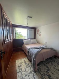 a bedroom with a large bed with a window at Apartamento Pé na Areia- Torres in Torres